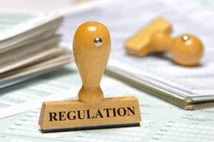 a rubber stamp with the word "regulation" standing on top of official looking forms